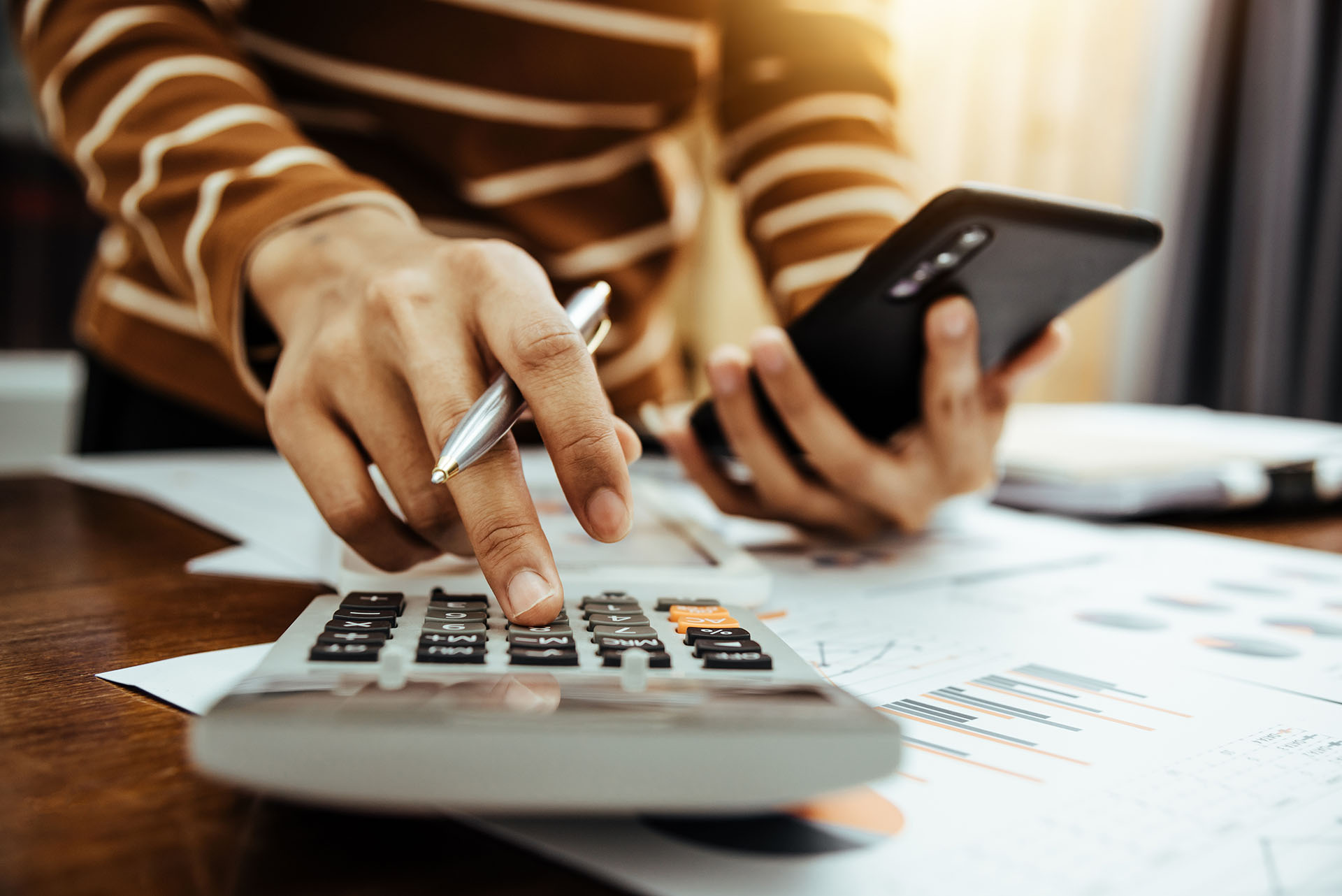 person with calculator and cell phone